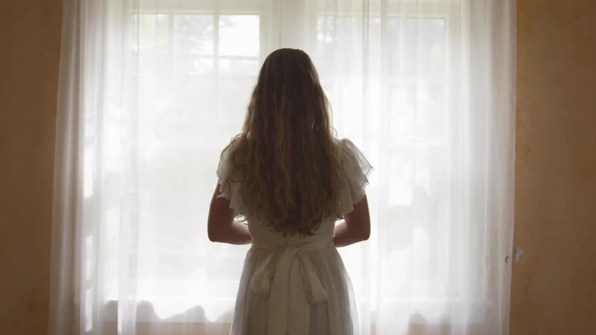 A woman is looking at a window