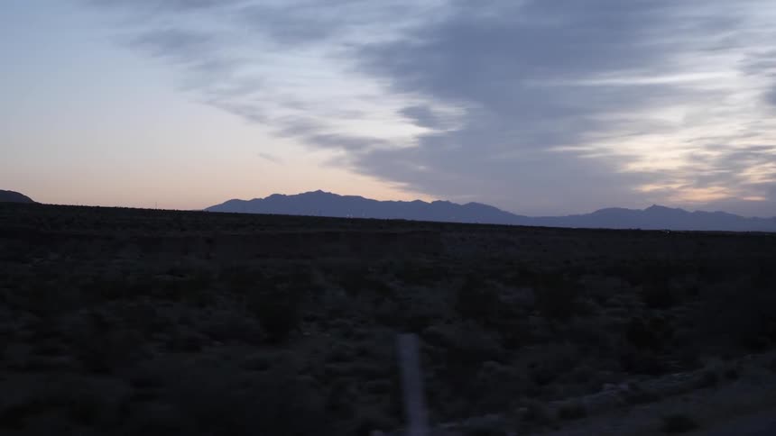 A dirt road in the desert at dusk