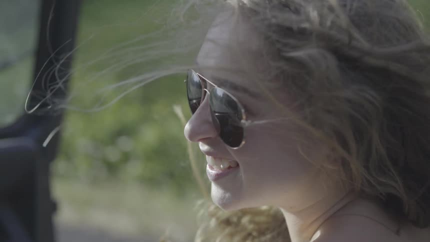 Girl smiles to driver while riding in vehicle