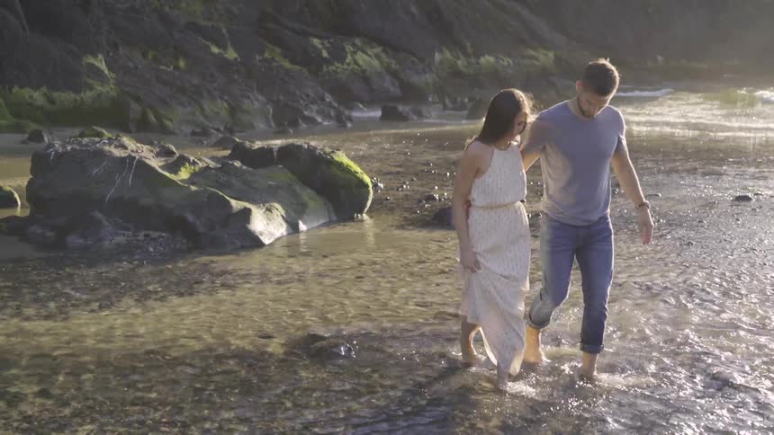 Man and woman walking in a pond