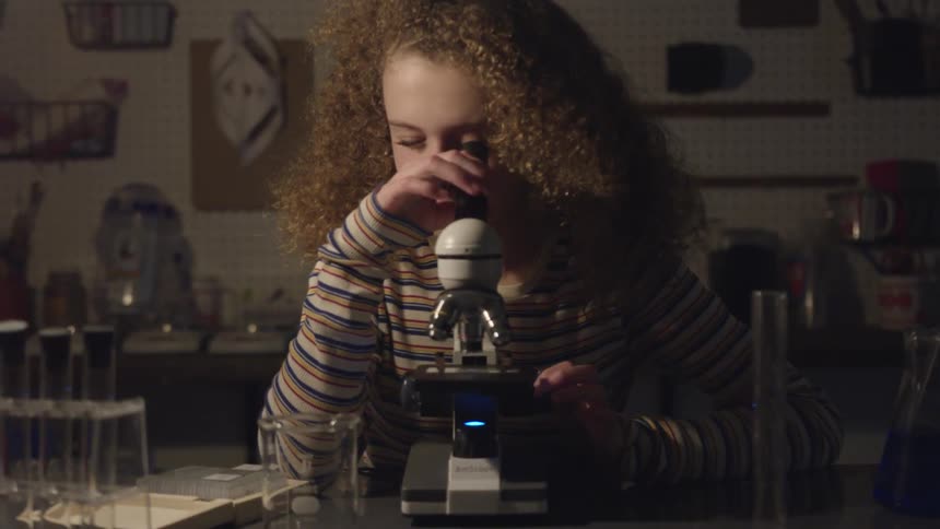 A girl looking through a microscope