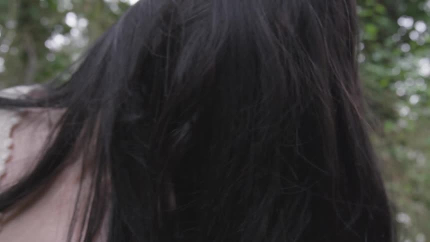 A woman in the forest moves her head