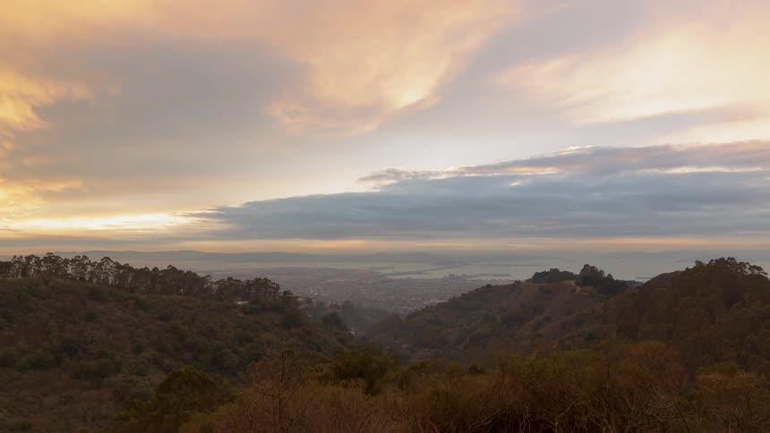 Clouds rolling over a mountain range and city