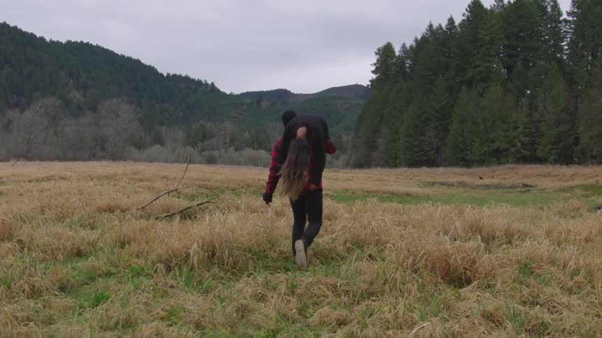 A man carried a woman on his shoulder across the plains