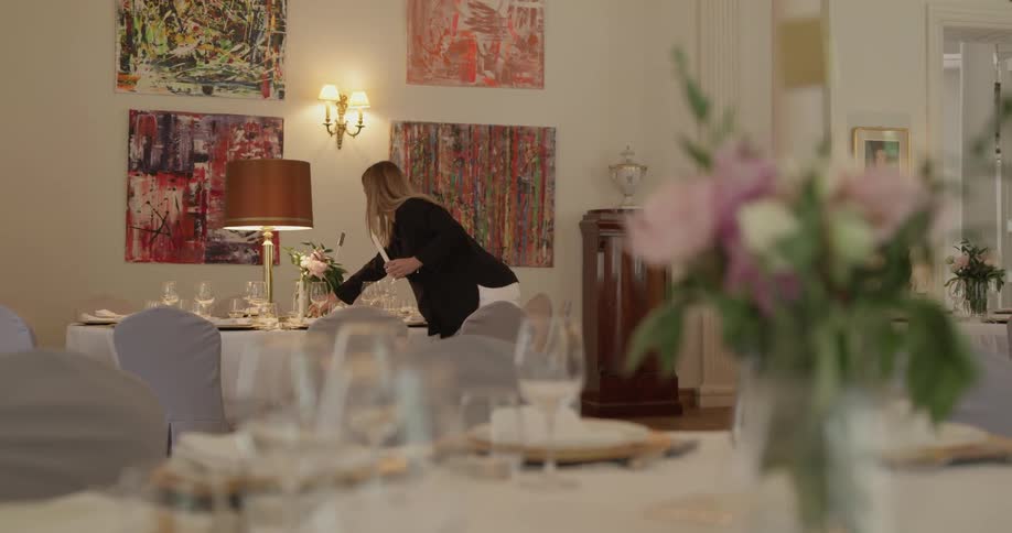 A woman is placing candles on a table