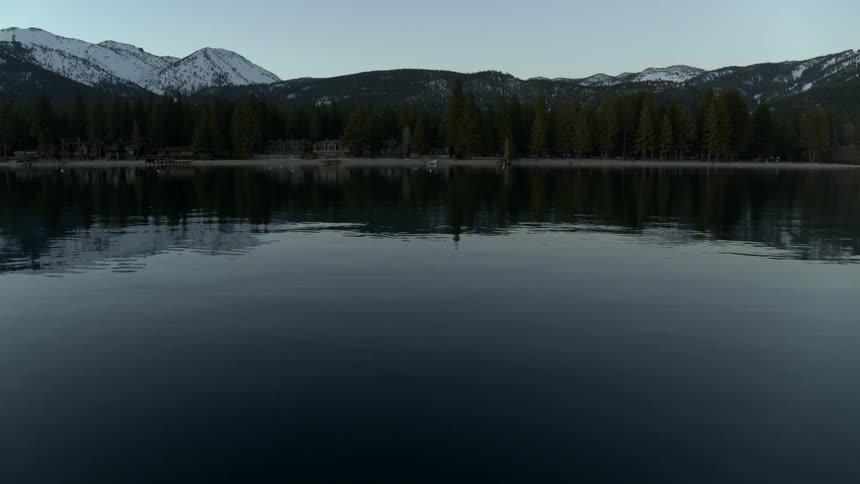 A river ripples next to a forest in the mountains
