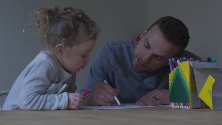 A man is showing a child how to draw