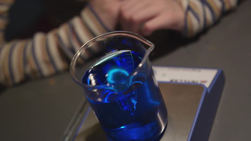 A beaker of blue liquid is weighed