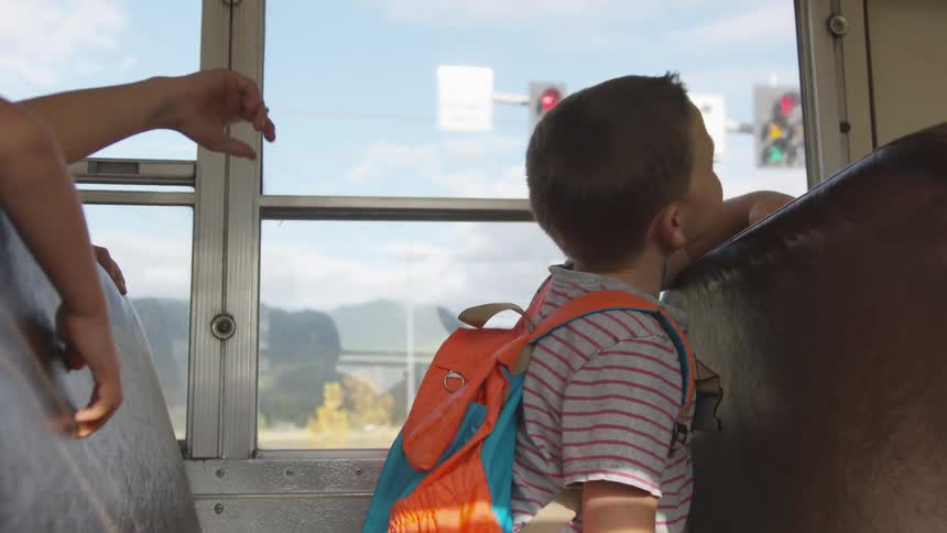Children sit in bus as it passes through intersection
