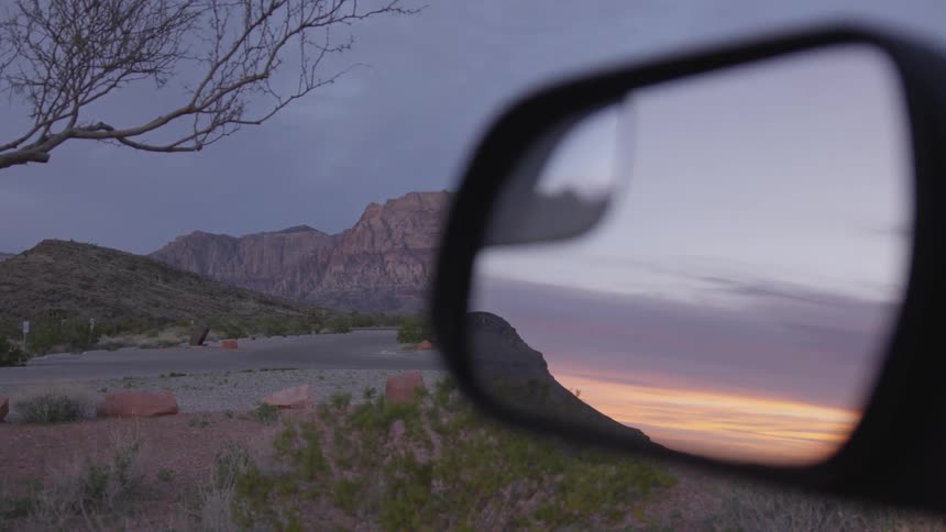 Mountains during sunset as viewed through a car mirror