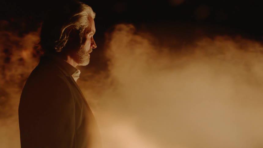 A man is standing by a fire