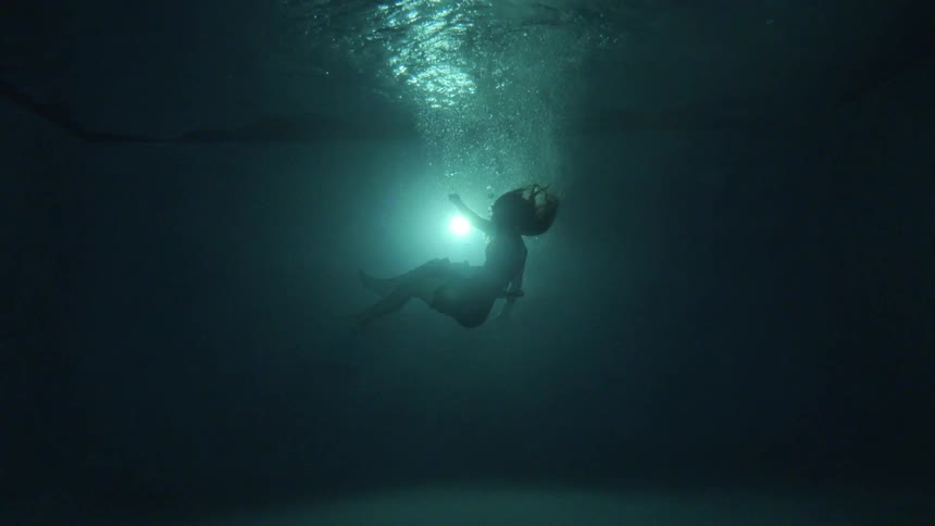 Woman sinking down underwater