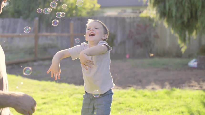 Boy plays with bubbles with a man