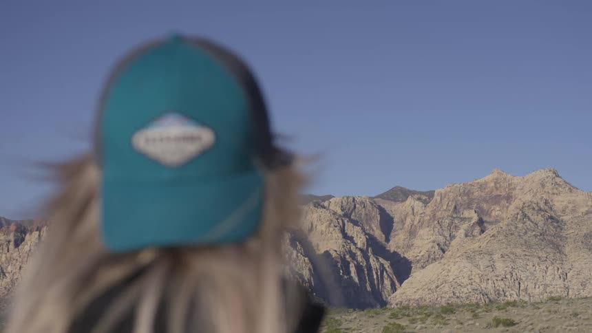 Female stares off at rocky hills at noon
