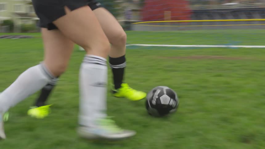 Two people playing soccer in a field