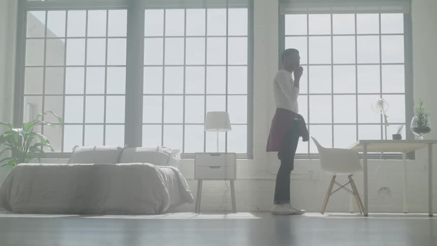 A man walking in a bright bedroom