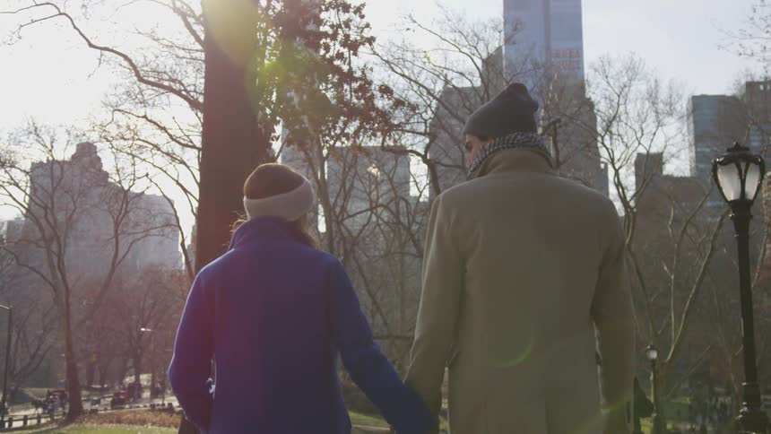 A man and woman holding hands outside
