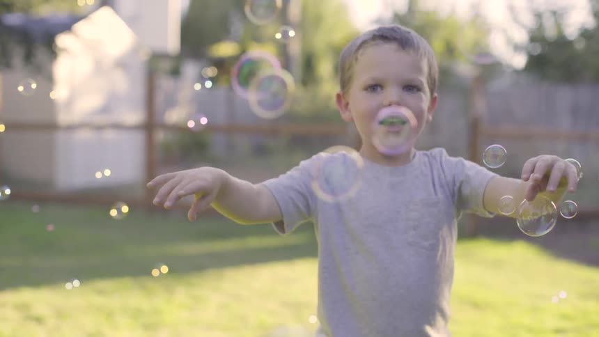 A small child playing with bubbles