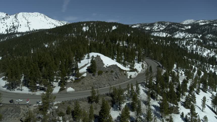A couple vehicles that are driving down a mountain range