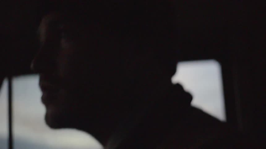 A man driving a car and staring out the windshield