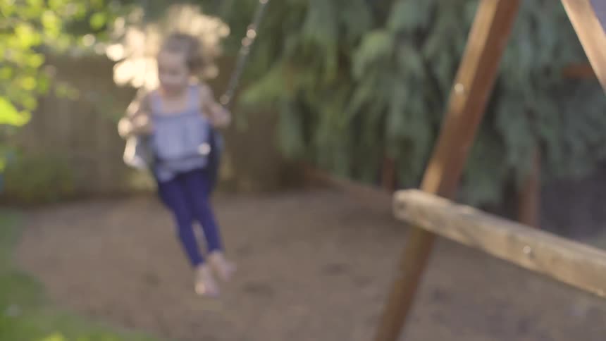 A girl playing on a swing