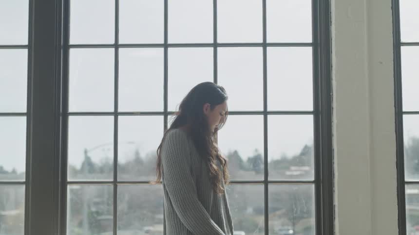A woman is staring out a window