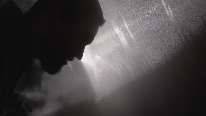 Man staring in a steamy and dark room