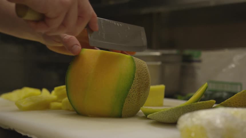 A person is cutting fruit with a knife
