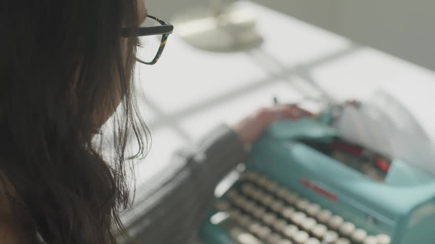 A woman uses an old typewriter