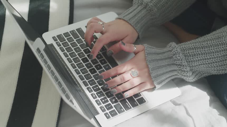A woman uses a macbook laptop