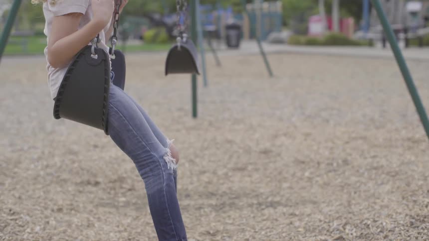 Young girl slowly swings