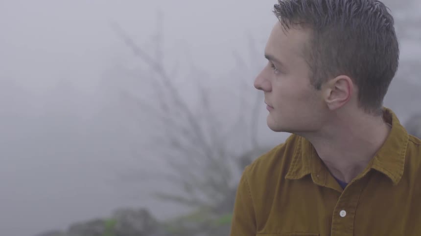 Man looks around under hazy sky during the day