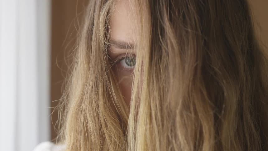 Woman stares with hair partially covering her face