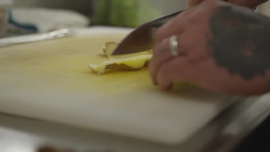 A person is cutting a potato