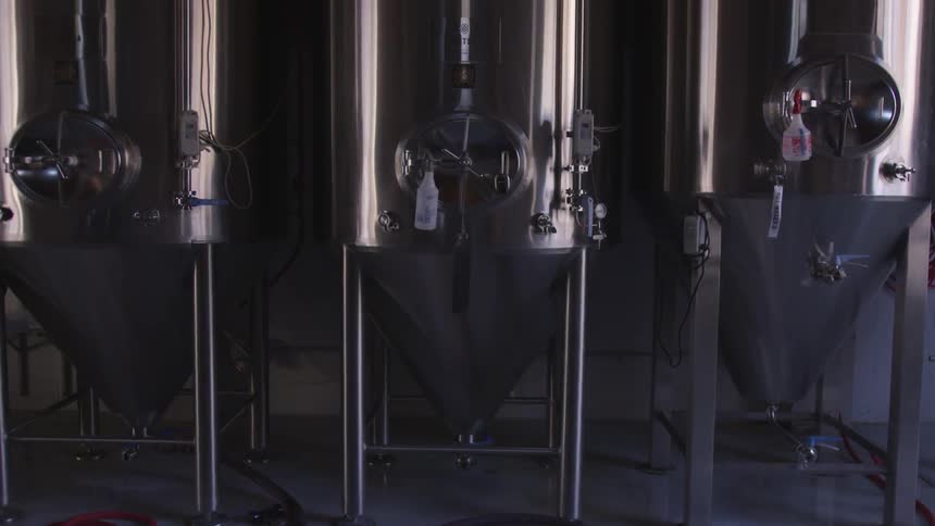 Three silver beer vats sit in a row
