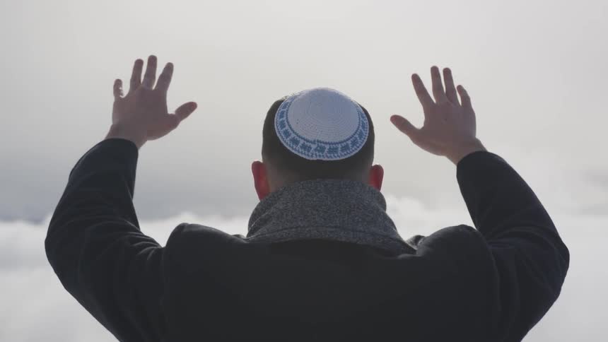 A man raises his hands to the sky