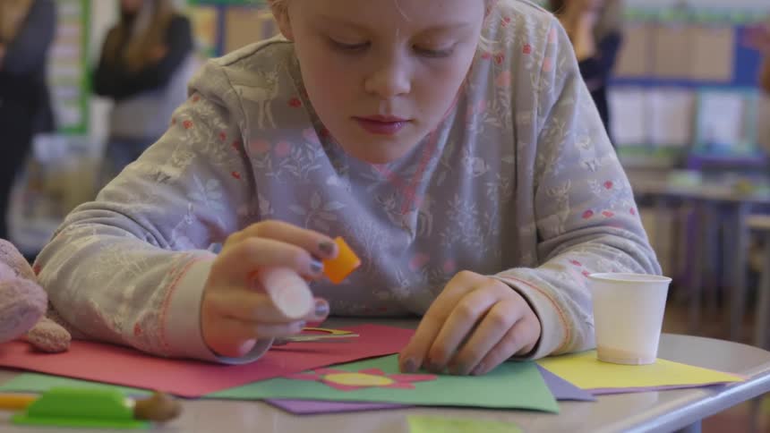 A child doing collage in a classroom