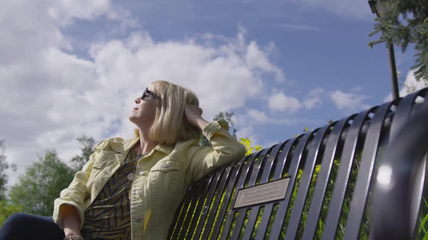A woman sitting on a bench outside