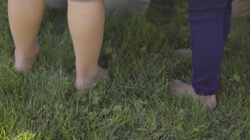 People stand barefoot on the grass