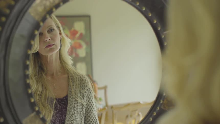 A woman looking at herself in the mirror