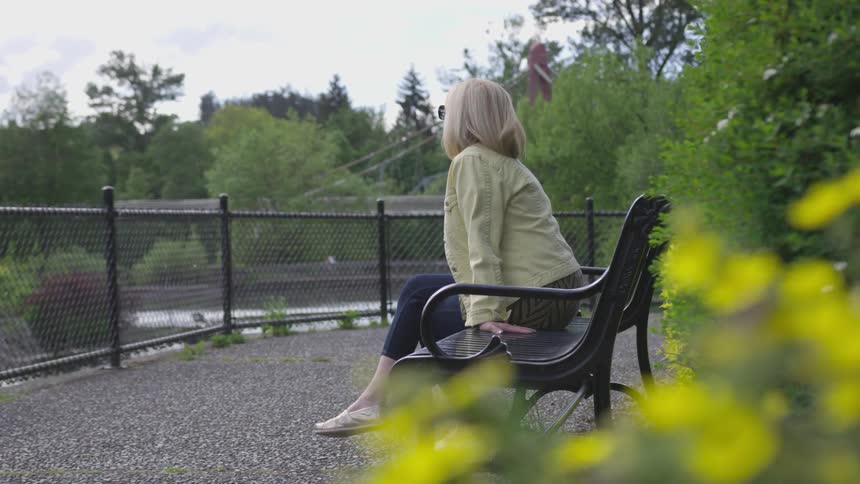A woman sitting on a bench in a park