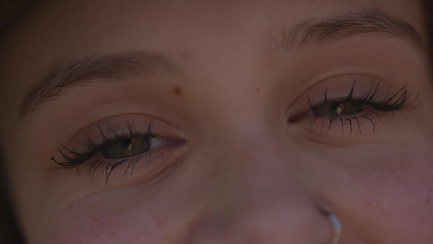 Close up view of woman's eyes while smiling and blinking