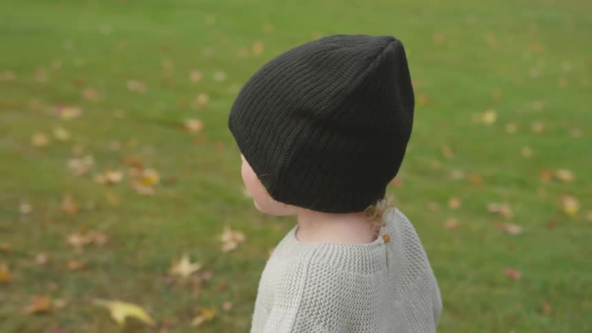 A child is walking outside in grass at daytime