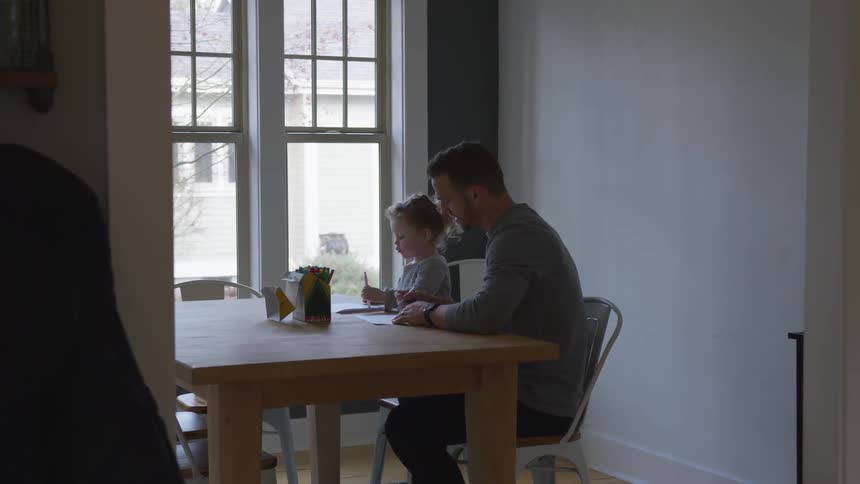 Man and child work at table