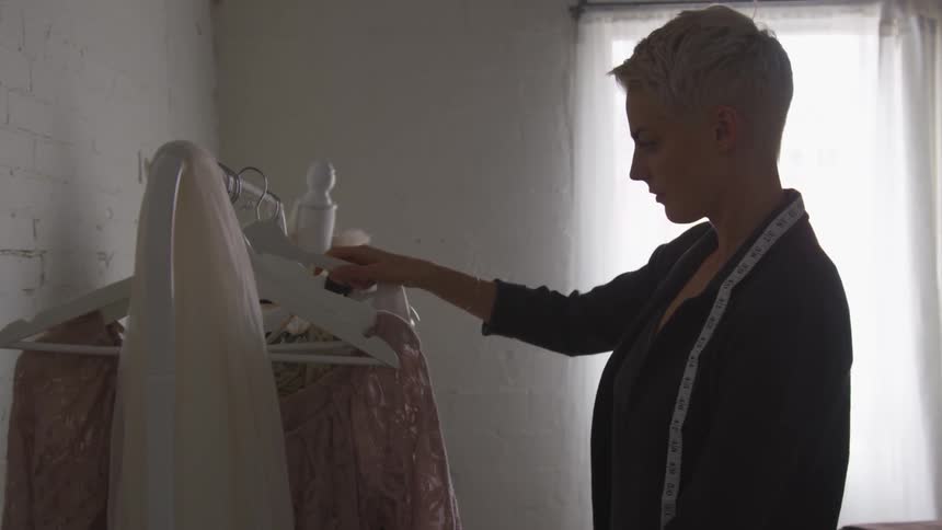 A woman looks through clothing on a rack
