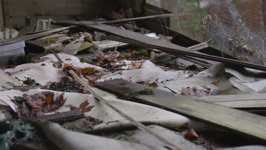 Wood boards and debris cover the ground
