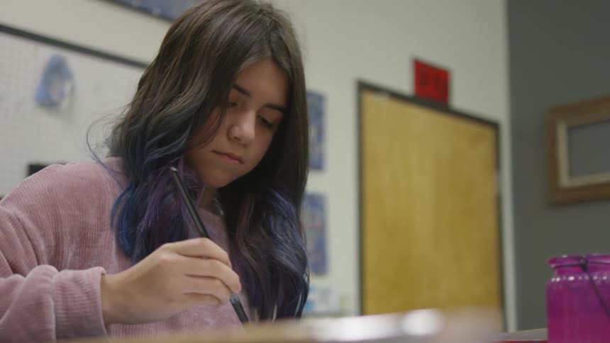 Girl paints with paintbrush