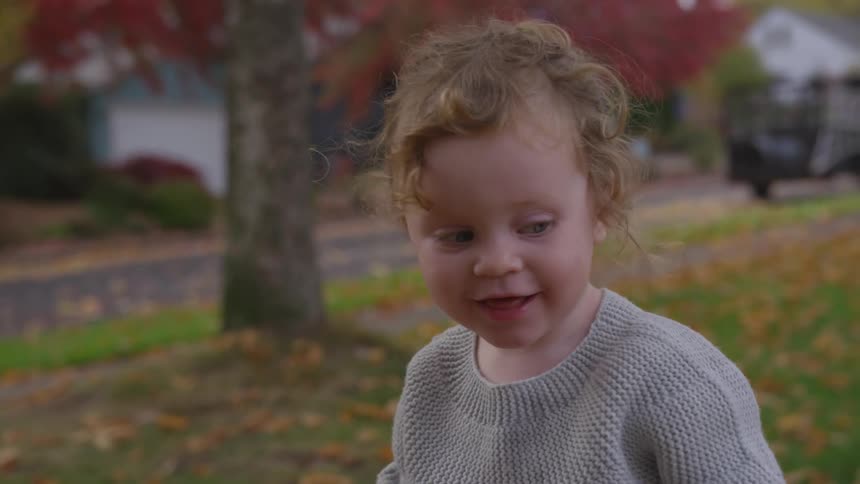 A young plays outside in the grass