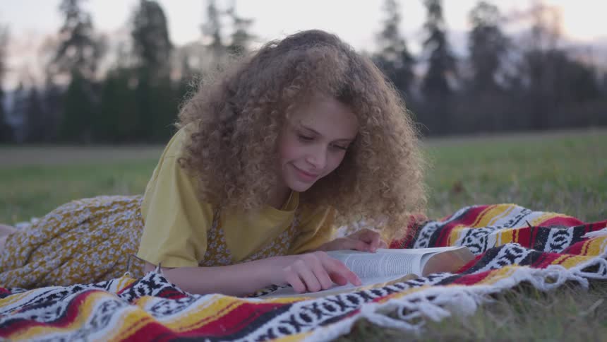 Girl Reading A Bible And Walking In A Field