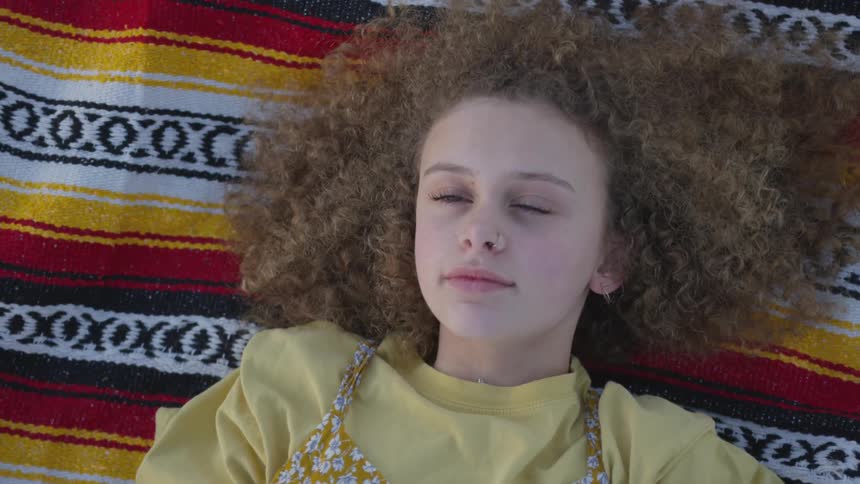 A girl laying on a blanket outdoors